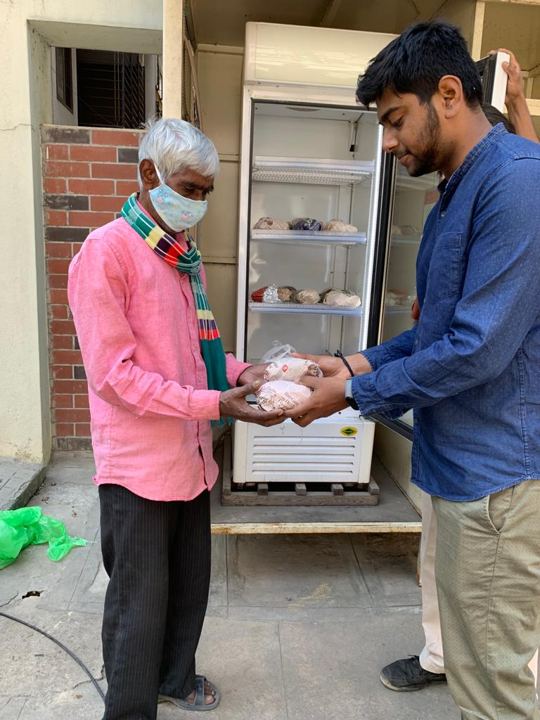 Volunteers handing out food from a public community fridge