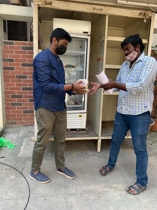 Volunteers handing out food from a public community fridge